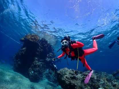 石垣島ダイビングで女性ダイバーが最高の透視度の中で水中ではしゃいでいる様子