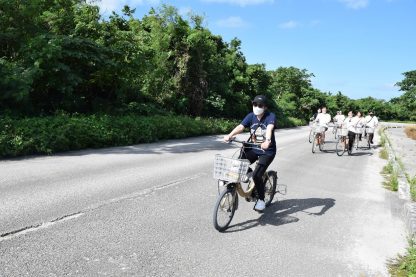 竹富島で自転車に乗って観光している様子。電動自転車の人が先頭で滑走